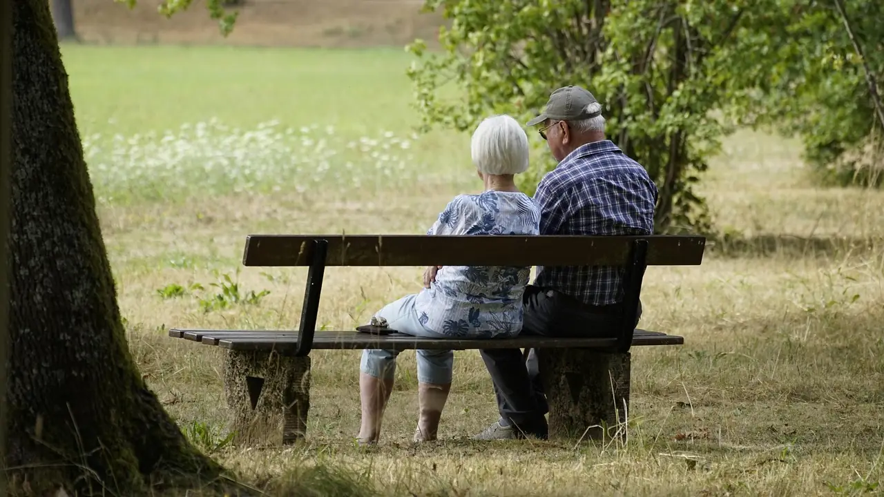 Pareja de jubilados paseando por un parque