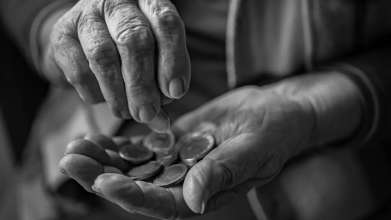 Hucha con monedas y billetes sobre una mesa